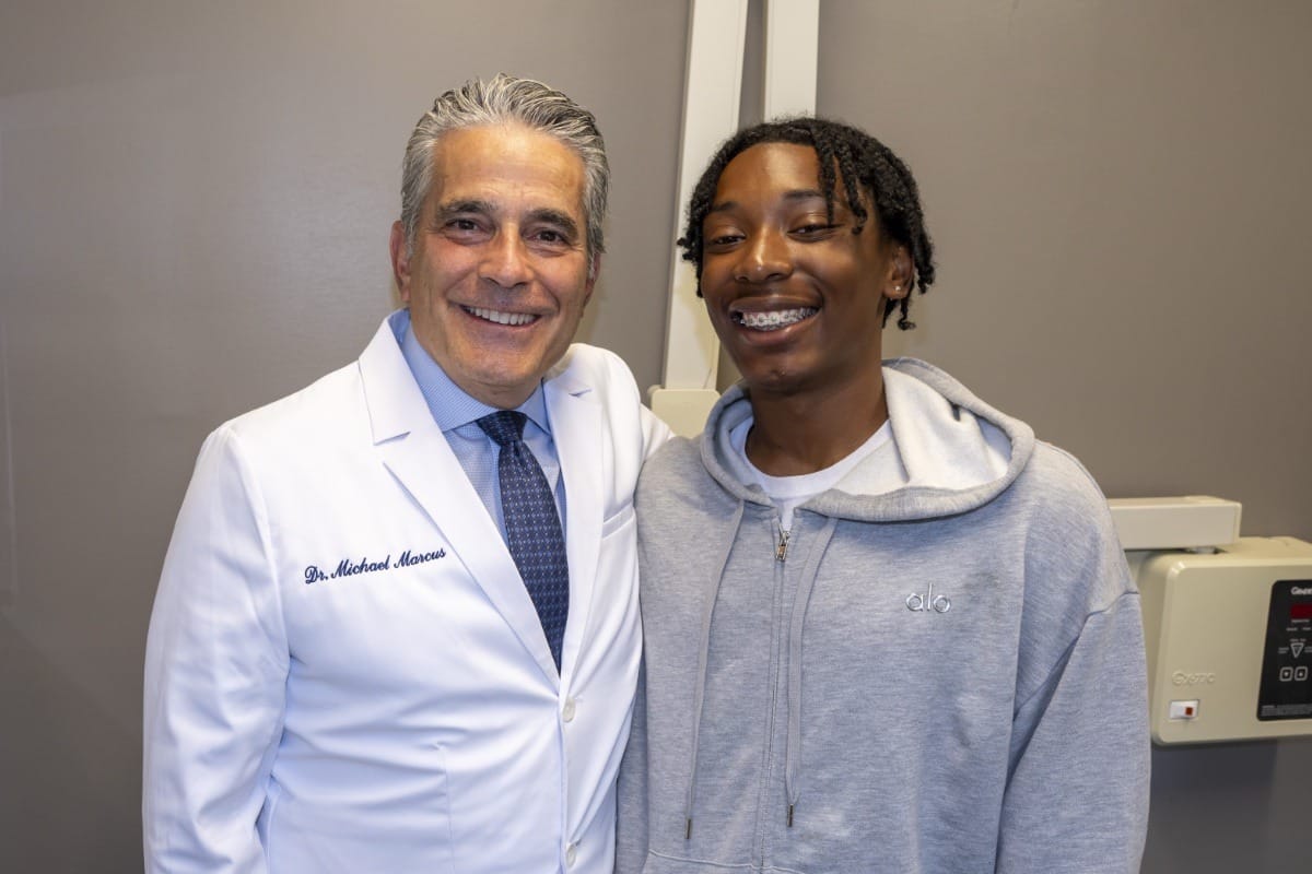 Dr. Marcus posing for a photo with a young patient