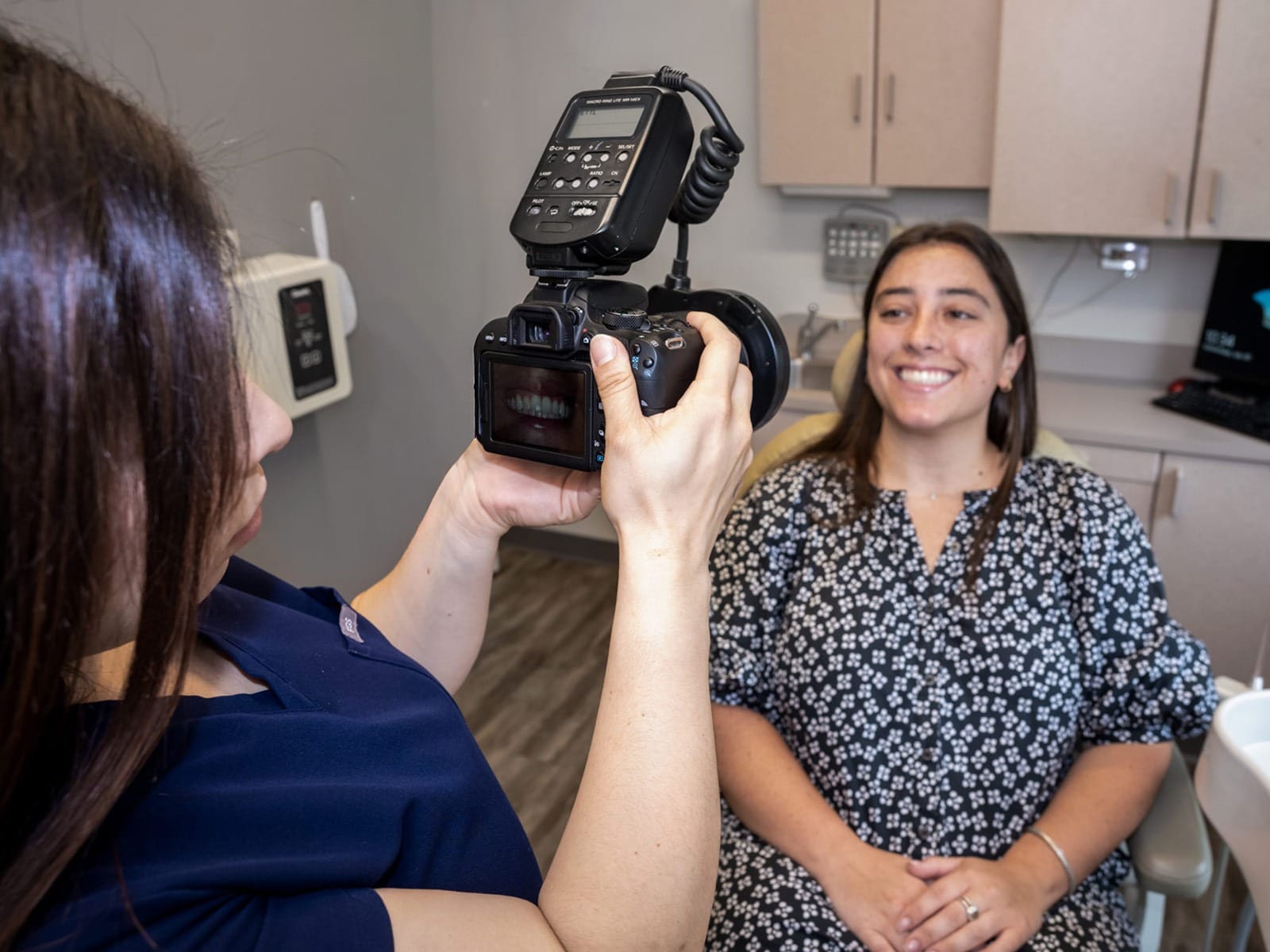 A dental assistant takes a picture of a patient's teeth