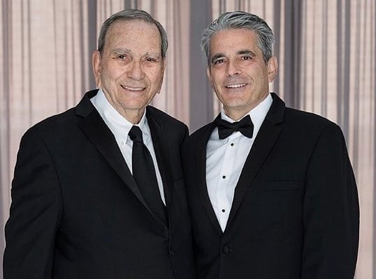Two men in formal black suits.