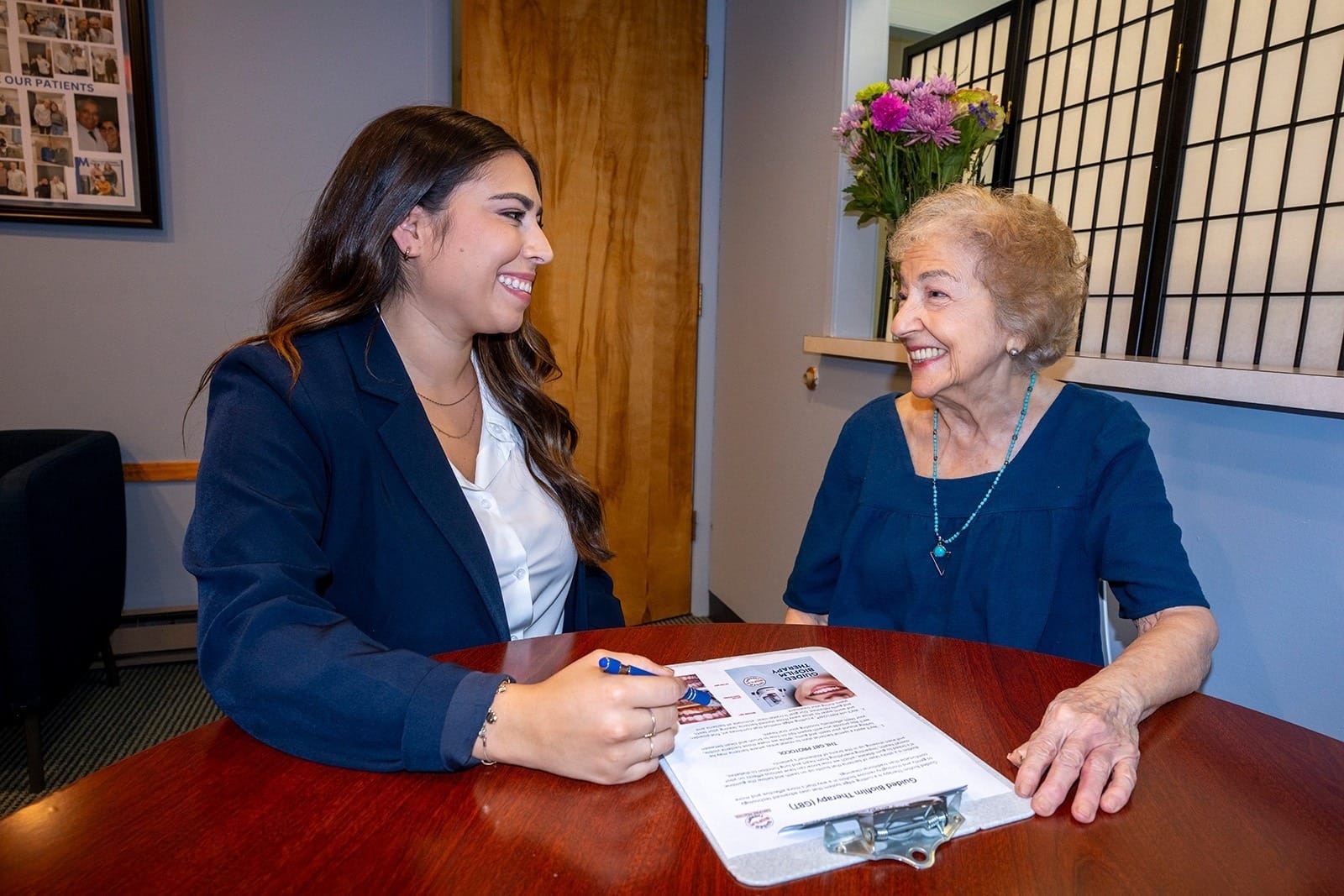 Two people discussing documents at table.