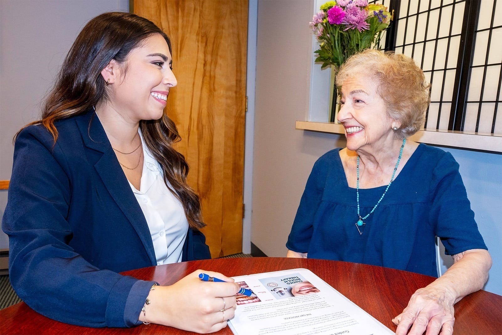 A dental assistant chats with a patient regarding treatment options